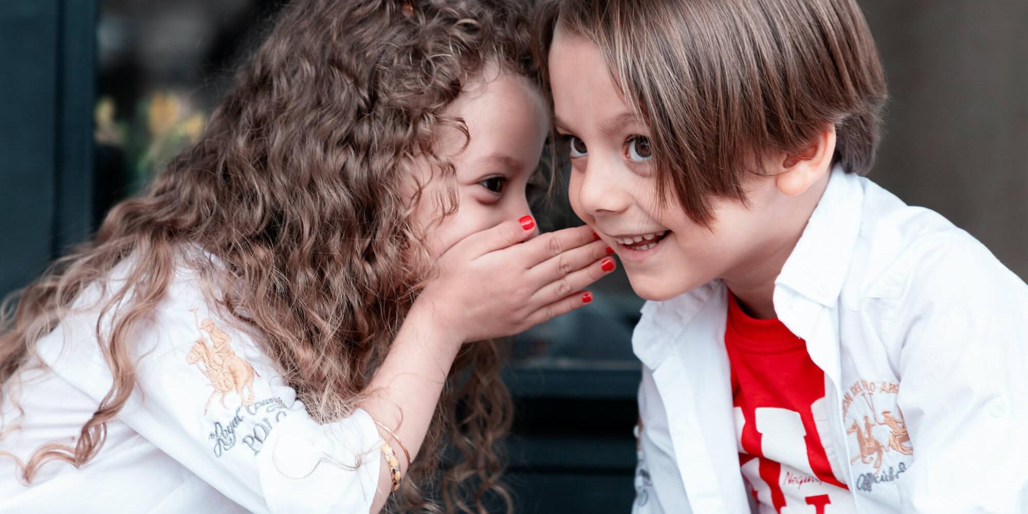Kinder flüstern sich etwas zu