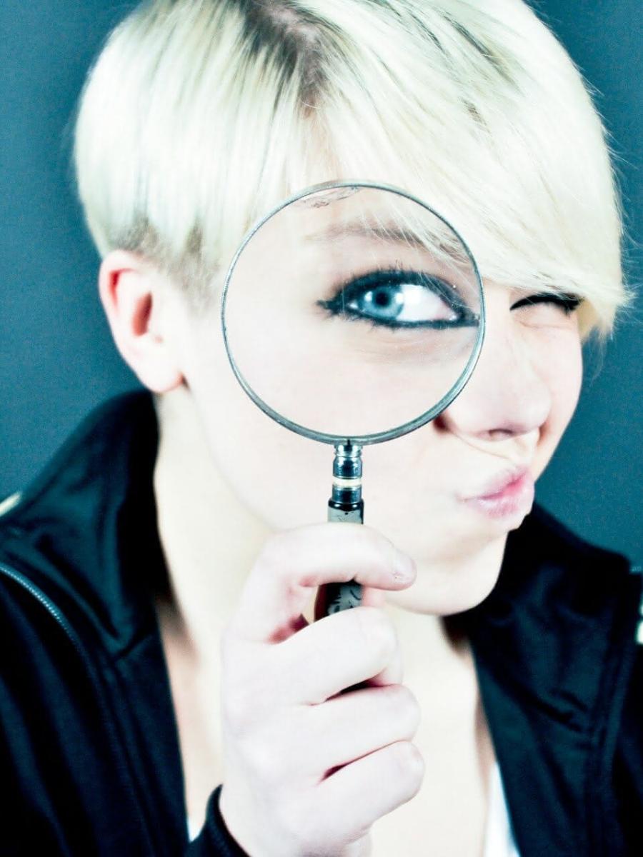 Frau schaut durch eine Lupe